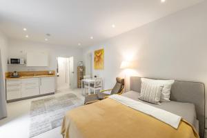 a white bedroom with a bed and a kitchen at Appartements an der Therme in Bad Ems +42 photos