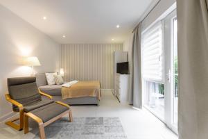 a bedroom with a bed and a chair and a television at Appartements an der Therme in Bad Ems
