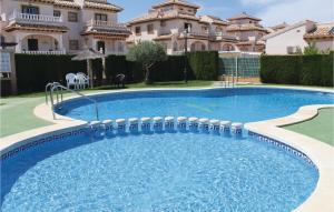 a large swimming pool in front of a house at 2 Bedroom Lovely Home In Orihuela Costa in Orihuela Costa