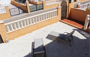 a patio with two chairs and a table and a building at 2 Bedroom Lovely Home In Orihuela Costa in Orihuela Costa +11 photos