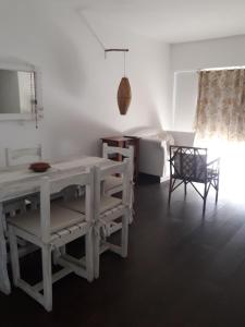 a white dining room with a table and chairs at Dpto Maipú in Chivilcoy