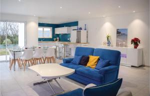 sala de estar con sofá azul y cocina en 3 Bedroom Beautiful Home In Matignon, en Matignon