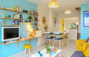 sala de estar con pared azul y TV en Cozy Home In Jullouville With House Sea View, en Jullouville-les-Pins