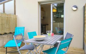 a wooden table with chairs and a bowl on it at 2 Bedroom Cozy Home In Jullouville in Jullouville-les-Pins +17 photos
