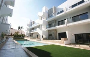 einen Blick nach außen auf ein Gebäude mit einem Pool in der Unterkunft Beautiful Apartment In Arenales Del Sol With Outdoor Swimming Pool in Arenales del Sol