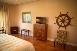 a bedroom with a bed and a tv and a wheel on the wall at Ocean Mist Guesthouse in Ucluelet