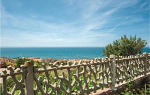 a wooden fence with the ocean in the background at Awesome Apartment In Porto Alabe in Magomadas