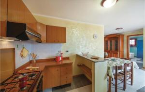 a kitchen with wooden cabinets and a counter top at Awesome Apartment In Porto Alabe in Magomadas +9 photos