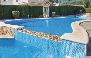 a blue swimming pool with rocks in the water at Awesome Apartment In Orihuela With Kitchen in Los Dolses