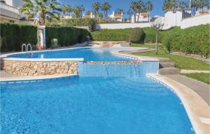 een zwembad in een resort met blauw water bij Awesome Apartment In Orihuela With Kitchen in Los Dolses