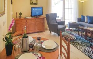a living room with a table and a television at Awesome Apartment In Orihuela With Kitchen in Los Dolses