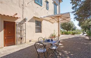 a table and chairs with an umbrella in front of a house at Le Cerbonche in Castiglioncello
