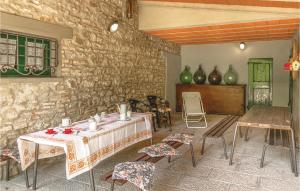 Habitación con mesa, sillas y pared de piedra. en Pet Friendly Home In Partina Ar With Kitchenette en Soci