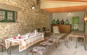 Habitación con mesa, sillas y pared de piedra. en Pet Friendly Home In Partina Ar With Kitchenette, en Soci