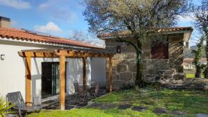 une terrasse d'une maison avec des chaises et un arbre dans l'établissement Lagar da Silveira, à Penafiel