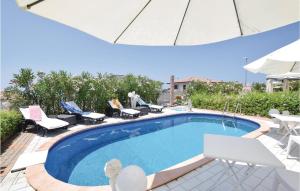 a swimming pool with chairs and an umbrella at Lovely Home In Tortora Praia A Mare With House Sea View in Praia a Mare