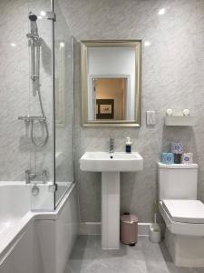 y baño con lavabo, ducha y aseo. en Stylish modern 3-bed house nr Manchester city ctr, en Whitefield