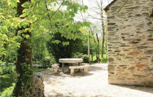 a picnic table in a park next to a stone building at 2 Bedroom Nice Home In La Gacilly in La Gacilly