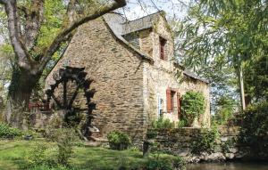 un vieux bâtiment en pierre situé sur le bord d'une rivière dans l'établissement Nice Home In La Gacilly With 2 Bedrooms And Wifi, à La Gacilly