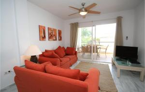ラ・カラ・デ・ミハスにあるGorgeous Apartment In Calahonda With Swimming Poolのリビングルーム(オレンジ色のソファ2台、テレビ付)