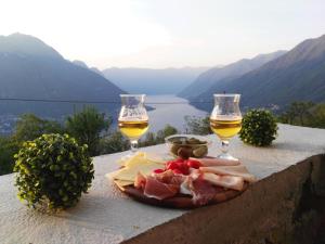 un plato de comida y dos copas de vino en Essentia Guest House en Faggeto Lario 