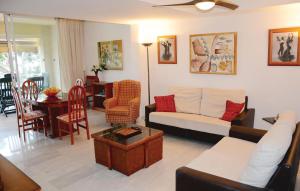 Beautiful Apartment In Port De Pollena With Kitchen في بورت دي بوينسا: غرفة معيشة مع أريكة وطاولة