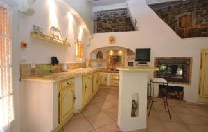 a large kitchen with yellow cabinets and a fireplace at Awesome Home In Bedousse With 2 Bedrooms, Outdoor Swimming Pool And Wifi in Malbosc