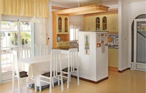 Il comprend une cuisine équipée d'une table blanche et d'un réfrigérateur. dans l'établissement Stunning Home In Torrevieja With 3 Bedrooms, Wifi And Outdoor Swimming Pool, à Torrevieja