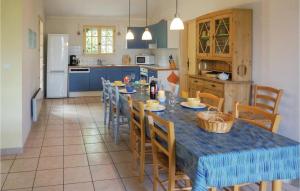 une cuisine avec une table et des chaises et une cuisine avec des armoires bleues dans l'établissement Cozy Home In St Pons De Mauchiens, à Saint-Pons-de-Mauchiens