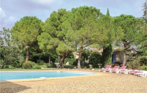 - une piscine bordée de chaises roses et d'arbres dans l'établissement 4 Bedroom Pet Friendly Home In St Pons De Mauchiens, à Saint-Pons-de-Mauchiens