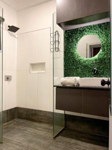 a bathroom with a sink and a green wall at Whytescape Serviced Apartments in Abuja