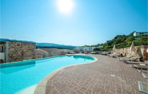 a swimming pool with chairs and umbrellas next to a resort at Trilo 6 in Baja Sardinia