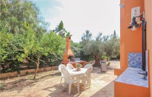 a patio with a table and chairs and trees at Villa Esmeralda in Menfi