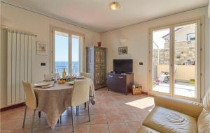 une salle à manger avec une table, des chaises et une télévision dans l'établissement Le Terrazze, à Santo Stefano al Mare