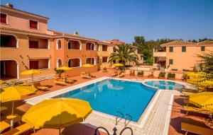 a swimming pool with yellow umbrellas and a building at Beautiful Apartment In Orosei With Wifi in Orosei