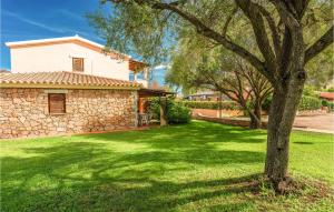 a house with a green yard with a tree at Trilo 6 in San Teodoro