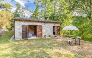 a small stone house with a table and an umbrella at Gioiara in Valfabbrica +11 photos
