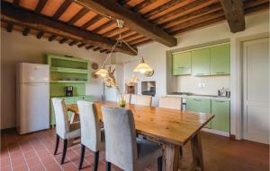 uma cozinha com uma mesa de madeira e armários verdes em Casa Gialla em Mazzolla