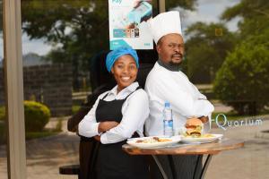 a man and a woman holding a table with food at Unji Lodge in Ndola