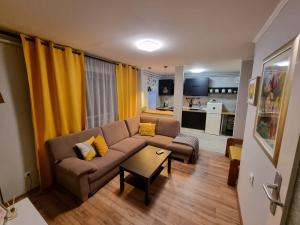 ein Wohnzimmer mit einem Sofa und einem Tisch in der Unterkunft Comfy apartment in Krasica