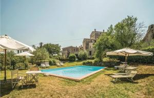 a swimming pool with chairs and umbrellas in a yard at Alabarda in Vasciano Nuovo