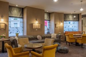 a living room with couches and tables and chairs at Hotel Litteraire Le Swann, BW Premier Collection in Paris