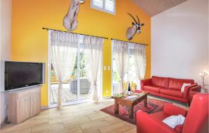 ein Wohnzimmer mit einem roten Sofa und einem TV in der Unterkunft Amazing Home In Espenel With Wifi in Espenel
