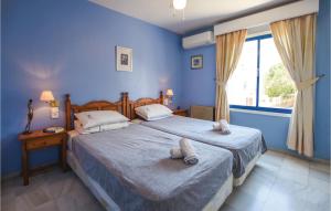 ein blaues Schlafzimmer mit zwei Betten und einem Fenster in der Unterkunft Gorgeous Home In Roquetas De Mar in Roquetas de Mar