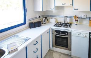 eine Küche mit weißen Schränken und einem Herd mit Backofen in der Unterkunft Gorgeous Home In Roquetas De Mar in Roquetas de Mar