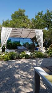 a pavilion with a white canopy in front of the water at Beach house Nada in Korčula