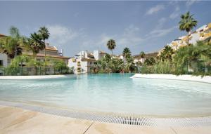 ラ・カラ・デ・ミハスにあるAwesome Apartment In La Cala De Mijas With 2 Bedrooms And Outdoor Swimming Poolのヤシの木が茂るリゾート内の大型スイミングプール