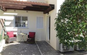 a patio with two chairs and a table and a tree at 2 Bedroom Cozy Home In Ciudad Quesada in Ciudad Quesada
