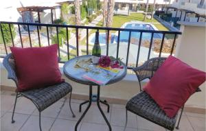 a table and two chairs with a bottle of wine on a balcony at 2 Bedroom Cozy Home In Ciudad Quesada in Ciudad Quesada