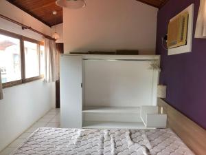 een slaapkamer met een wit bed en een paarse muur bij Horizonte da serra 1 in Gravatá